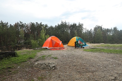 Photo of Camping tents and accessories in wilderness near forest