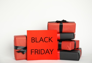 Many gift boxes and sheet of paper with words Black Friday on white background