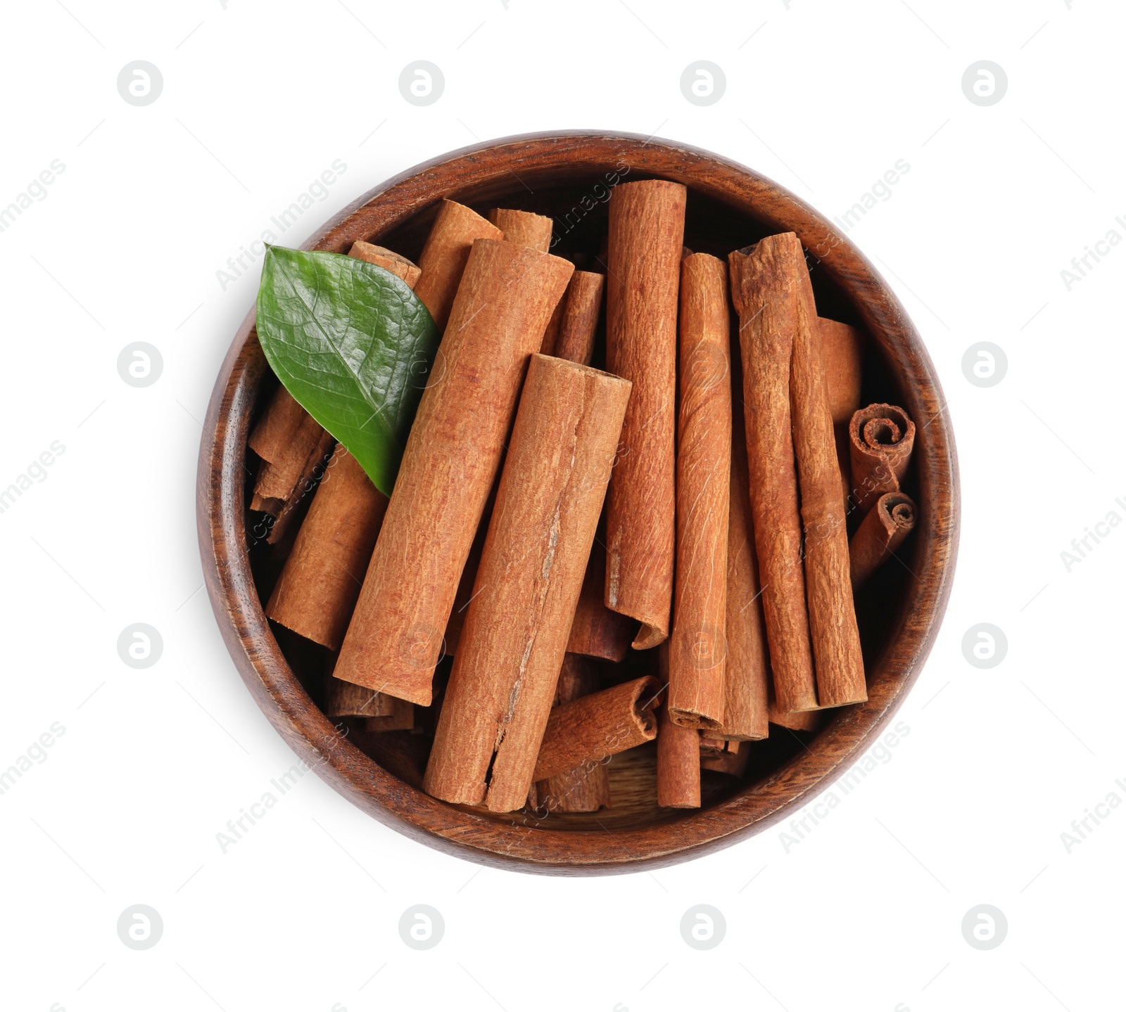 Photo of Cinnamon sticks and green leaf in bowl isolated on white, top view