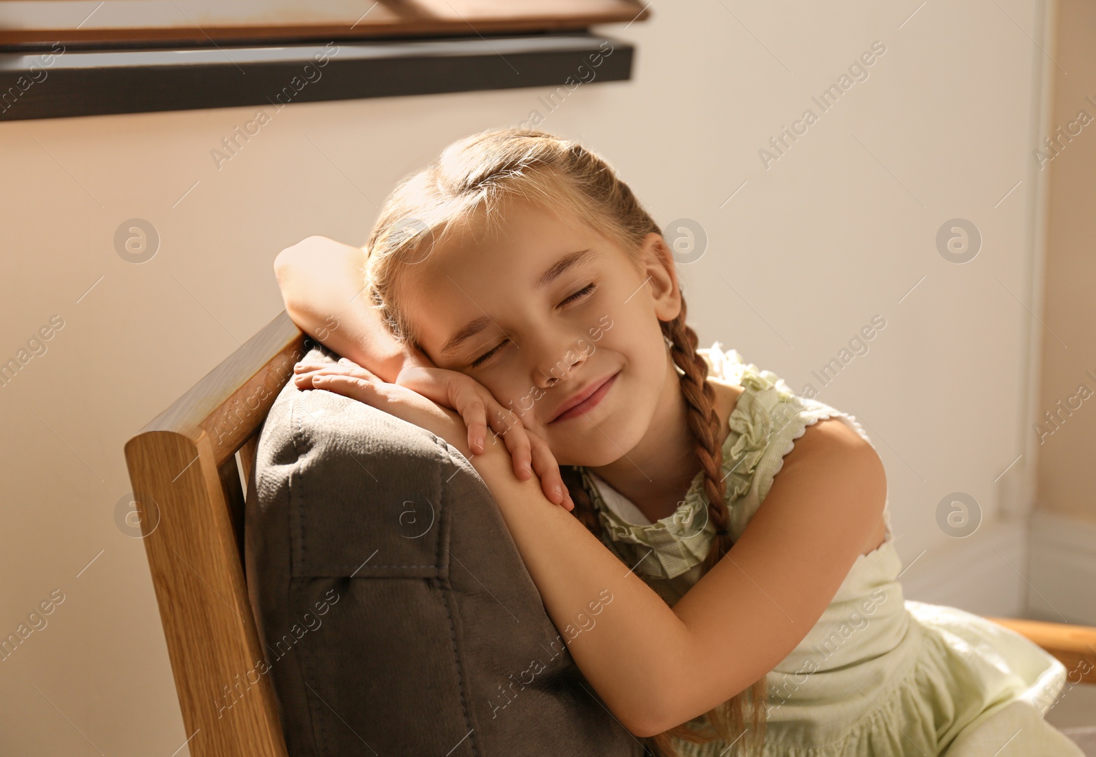 Photo of Little girl sleeping in armchair at home