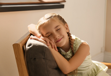 Little girl sleeping in armchair at home