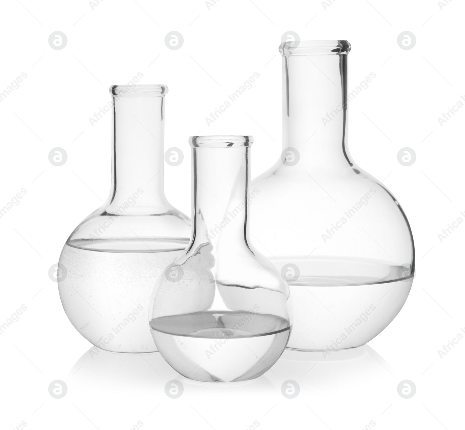 Photo of Flasks with transparent liquid on white background