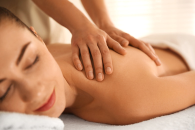 Photo of Young woman receiving back massage in spa salon, closeup