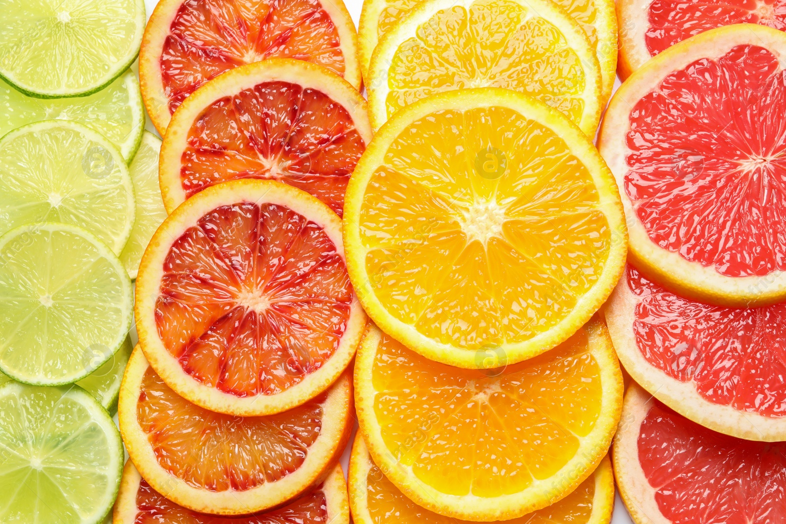 Photo of Slices of fresh citrus fruits as background, top view