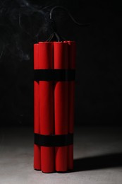 Dynamite bomb on grey table against black background