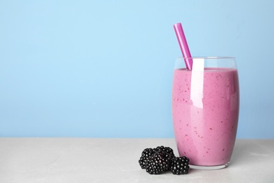 Delicious blackberry smoothie in glass on light table