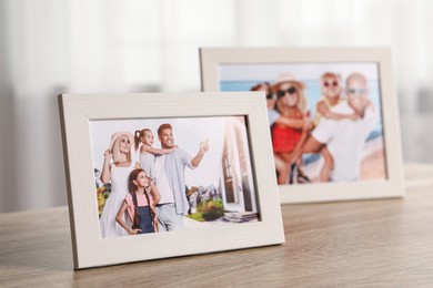 Photo of Pleasant memories. Frames with family photos on wooden table indoors, selective focus