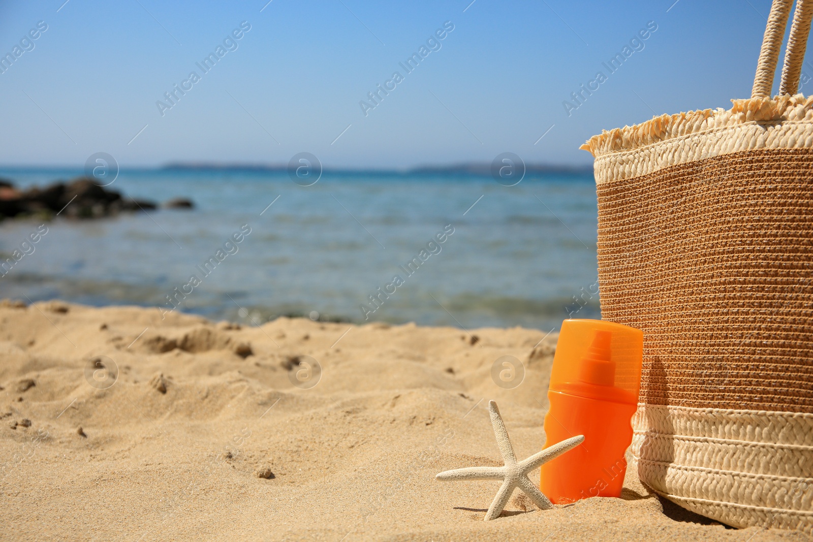 Photo of Sunscreen, starfish and bag on beach, space for text. Sun protection care