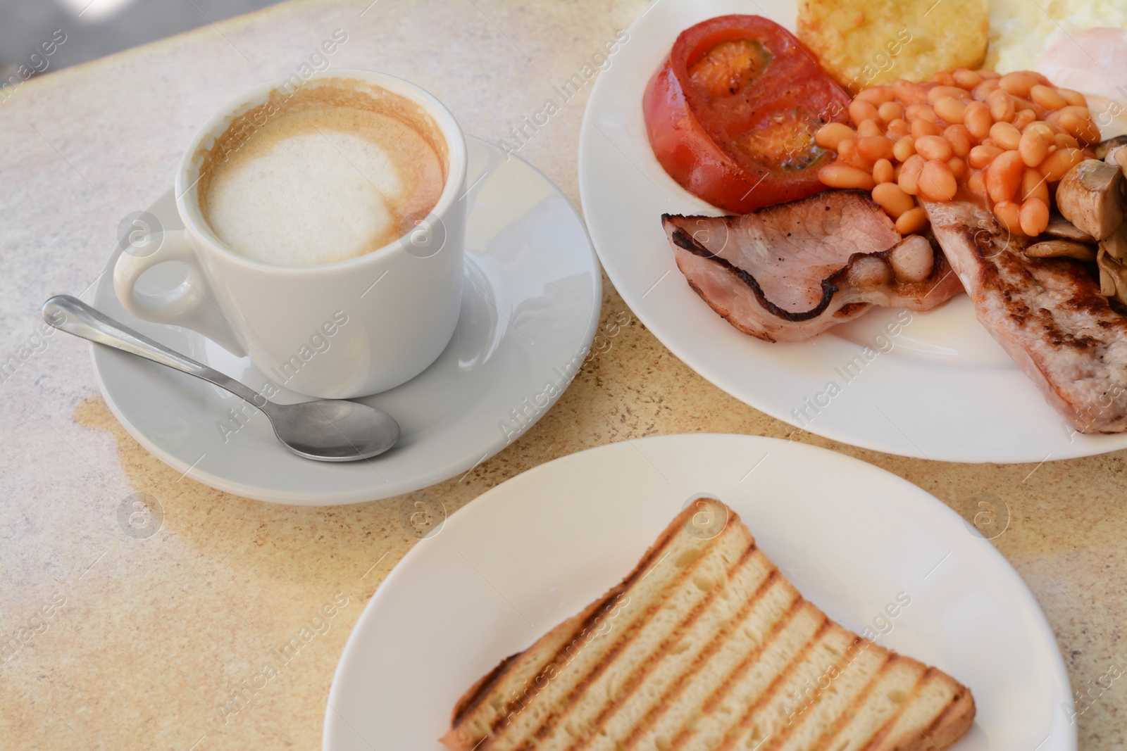 Photo of Delicious breakfast with fried meat and vegetables served on beige table