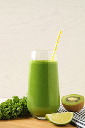 Photo of Tasty fresh kale smoothie and ingredients on table