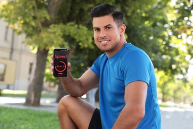 Man showing smartphone with fitness app outdoors
