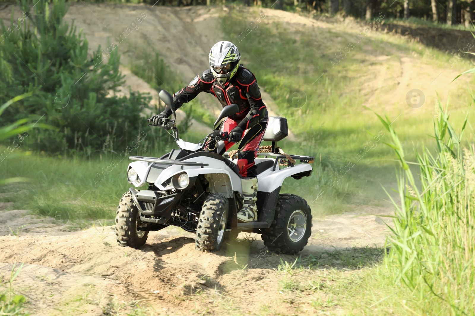 Photo of Man driving modern quad bike on sandy road. Extreme sport