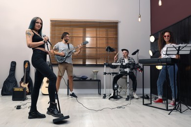 Photo of Music band performing in modern recording studio