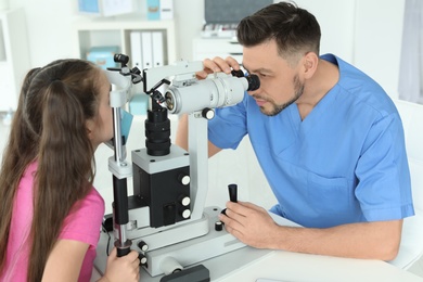 Ophthalmologist examining little girl in clinic