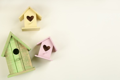 Beautiful bird houses on beige background, flat lay. Space for text