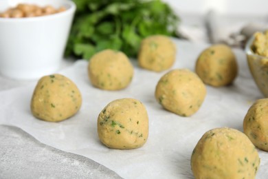 Photo of Raw falafel balls on grey table, closeup