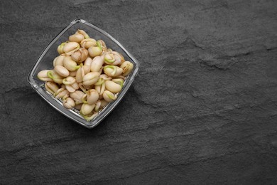 Photo of Sprouted kidney beans in bowl on black table, top view. Space for text