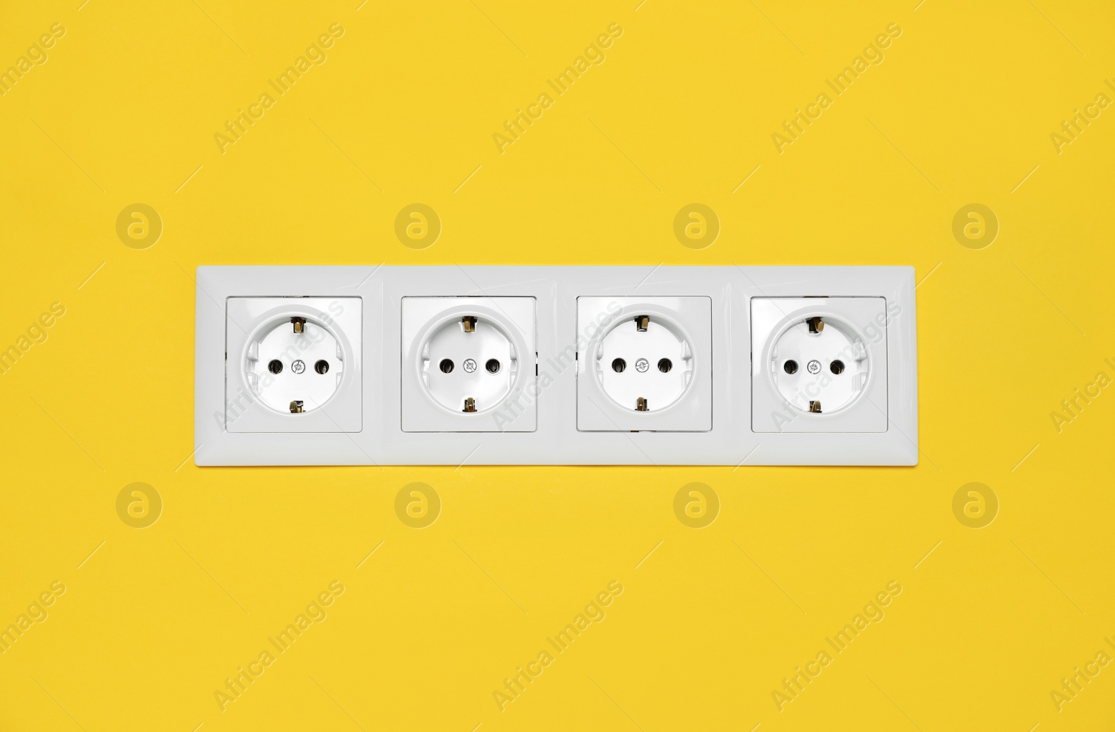 Photo of Power sockets on yellow wall. Electrical supply