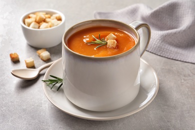 Photo of Mug of tasty sweet potato soup served on table