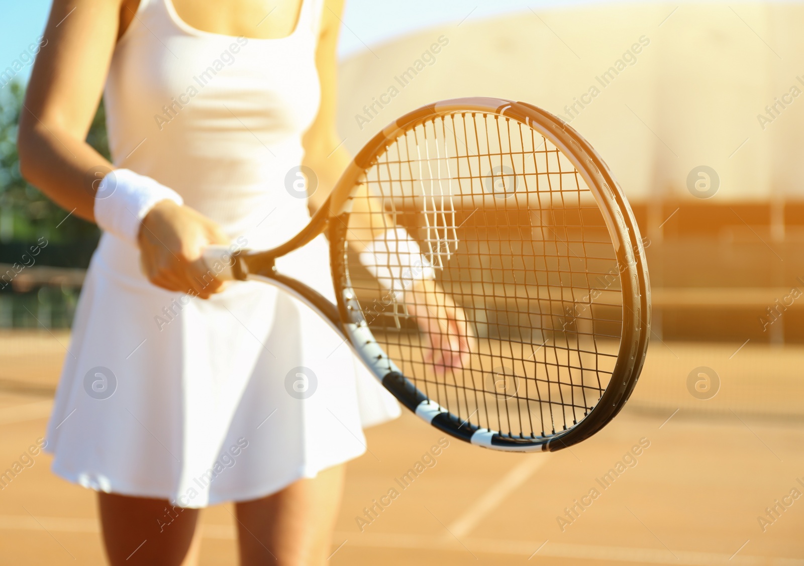 Photo of Sportswoman playing tennis at court on sunny day, closeup