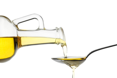 Photo of Pouring cooking oil from jug into spoon on white background