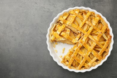 Photo of Tasty homemade quince pie on grey table, top view. Space for text