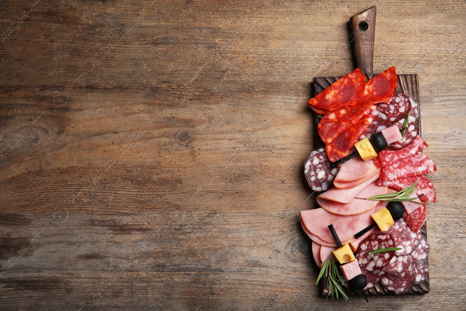 Photo of Tasty ham with other delicacies served on wooden table, top view. Space for text