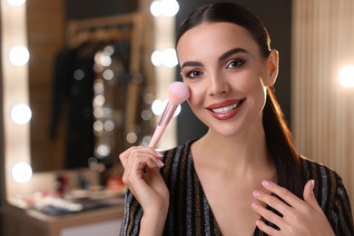 Bright makeup. Beautiful woman applying face powder in dressing room, space for text