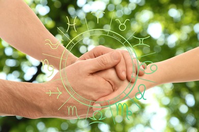 Image of Relationships and horoscope. Zodiac wheel and photo of man and woman holding hands outdoors, closeup