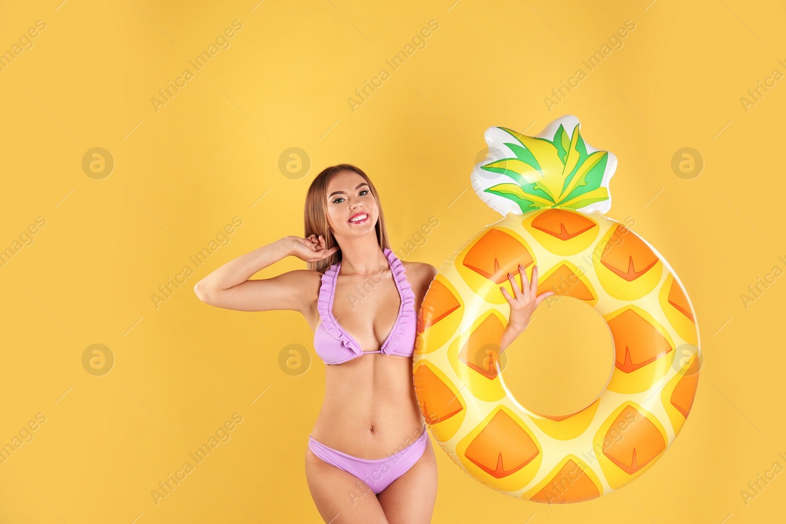 Photo of Pretty sexy woman in stylish bikini with inflatable ring on color background