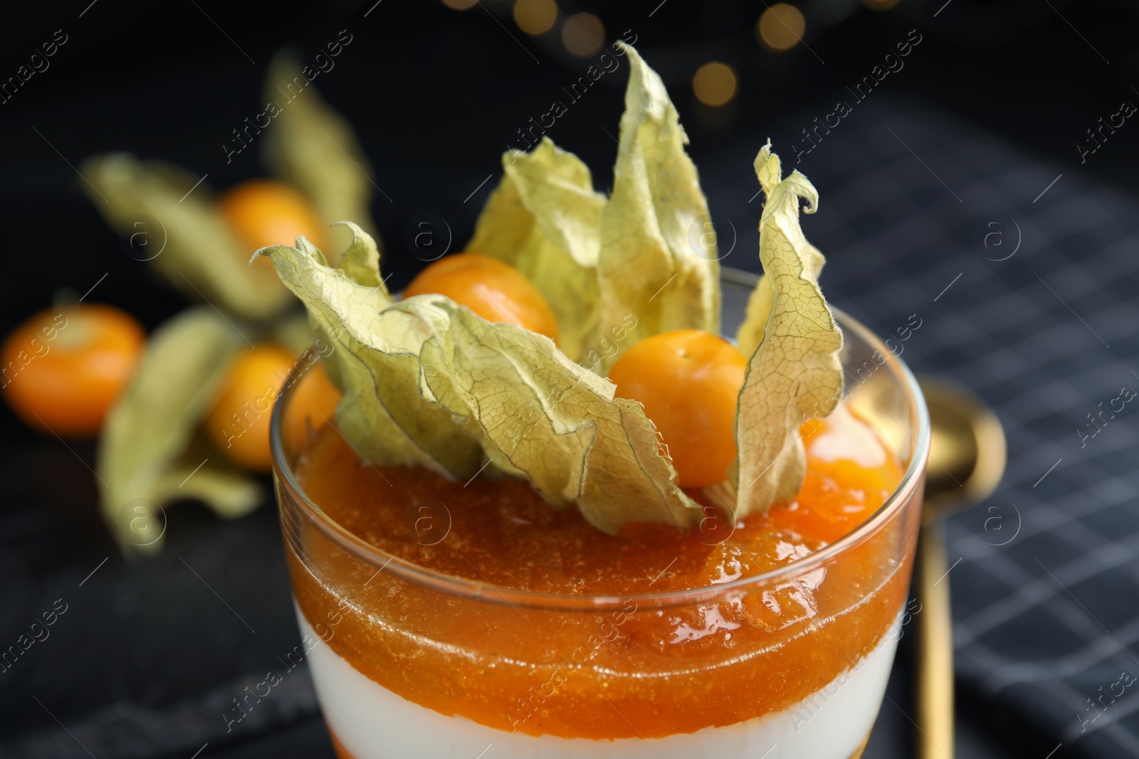 Photo of Delicious dessert decorated with physalis on table, closeup