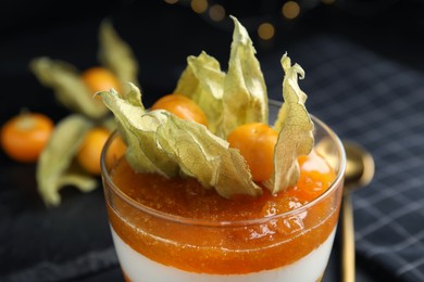 Photo of Delicious dessert decorated with physalis on table, closeup