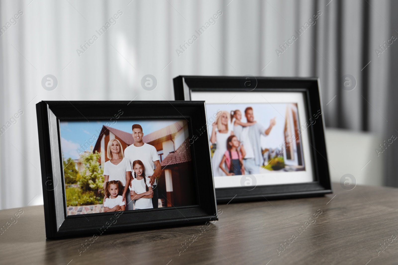 Photo of Frames with family photos on wooden table indoors