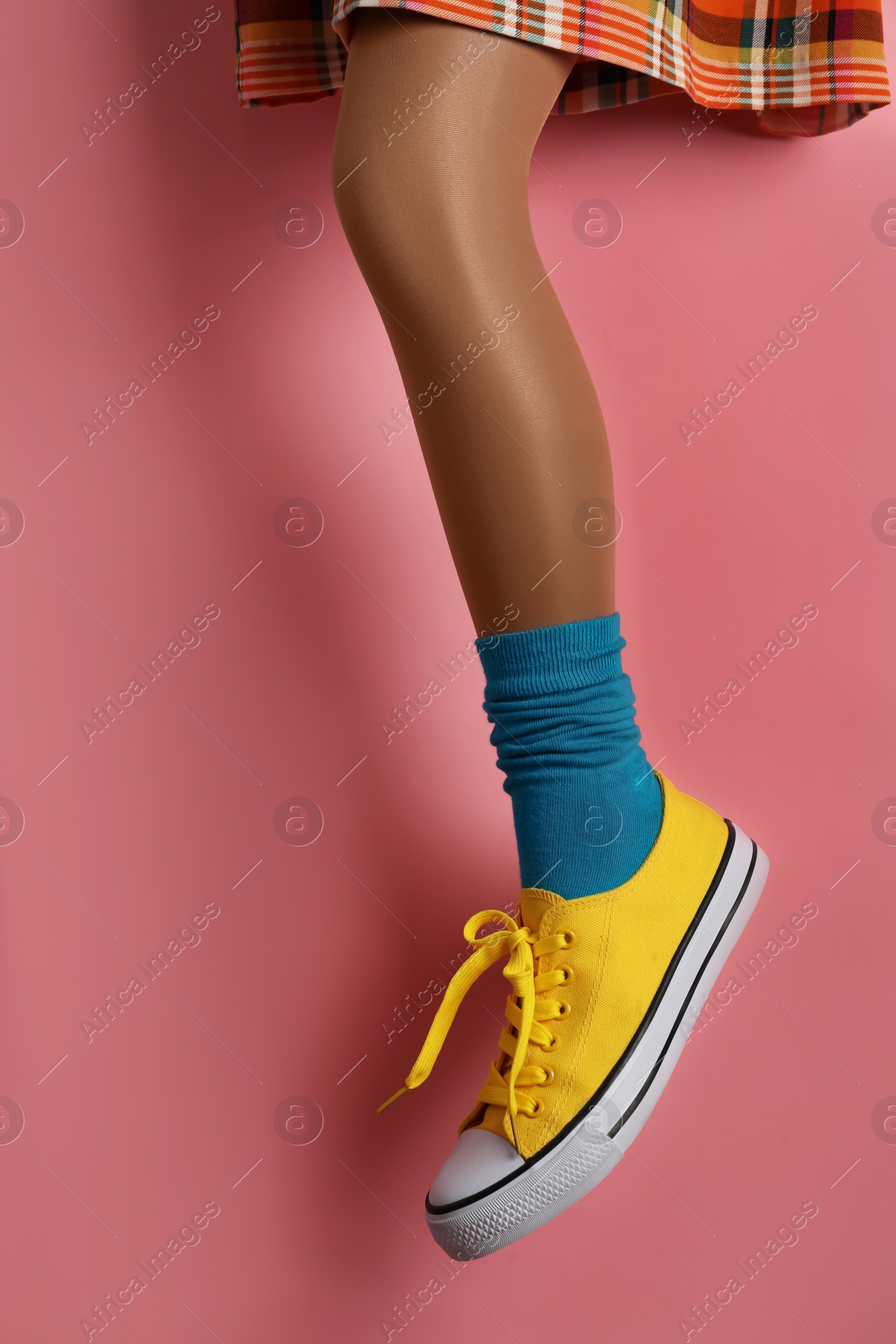 Photo of Woman wearing shoes on pink background, closeup