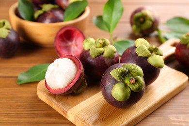 Photo of Fresh ripe mangosteen fruits on wooden table