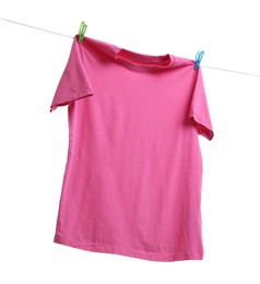 Pink t-shirt drying on washing line against white background