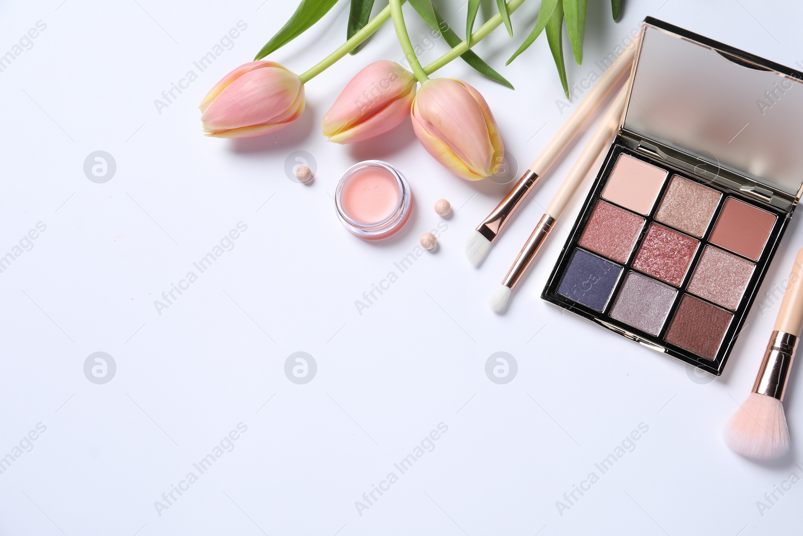 Photo of Flat lay composition with makeup products and beautiful tulips on white background. Space for text