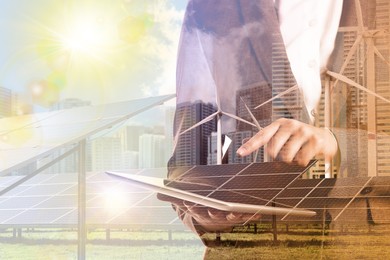 Image of Multiple exposure of businesswoman with tablet, wind turbines and solar panels installed outdoors. Alternative energy source