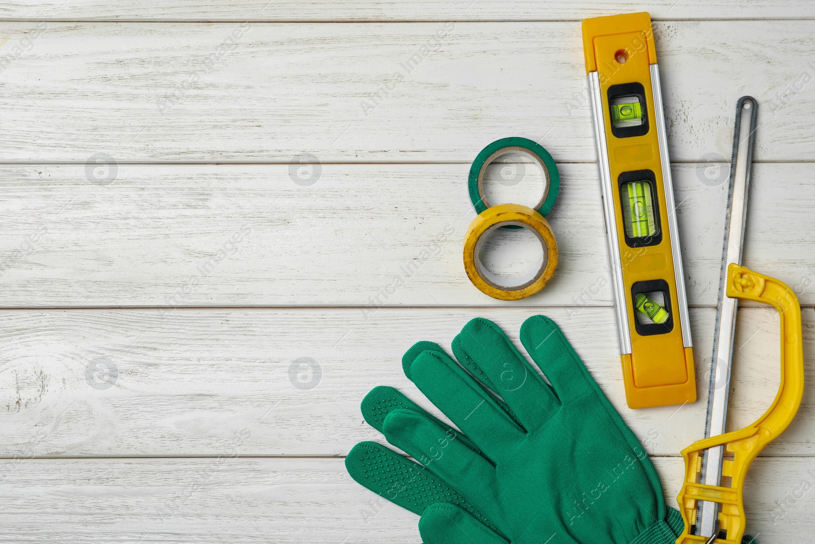 Photo of Flat lay composition with carpenter's tools on white wooden background. Space for text