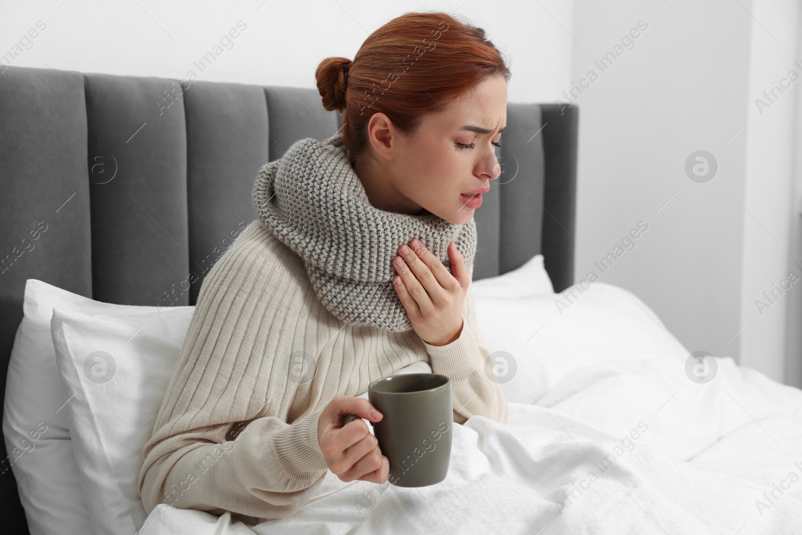 Photo of Woman with cup of drink and tissue coughing at home, space for text. Cold symptoms