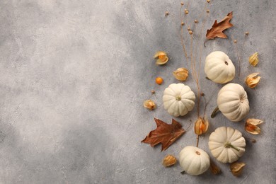 Flat lay composition with different fresh ripe pumpkins on light grey table, space for text