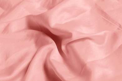 Pink shiny fabric as background, closeup view