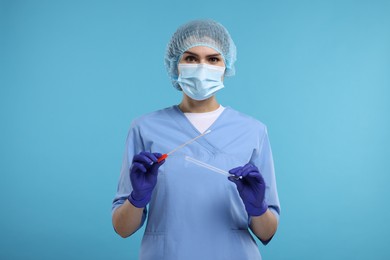 Laboratory testing. Doctor with cotton swab and tube on light blue background