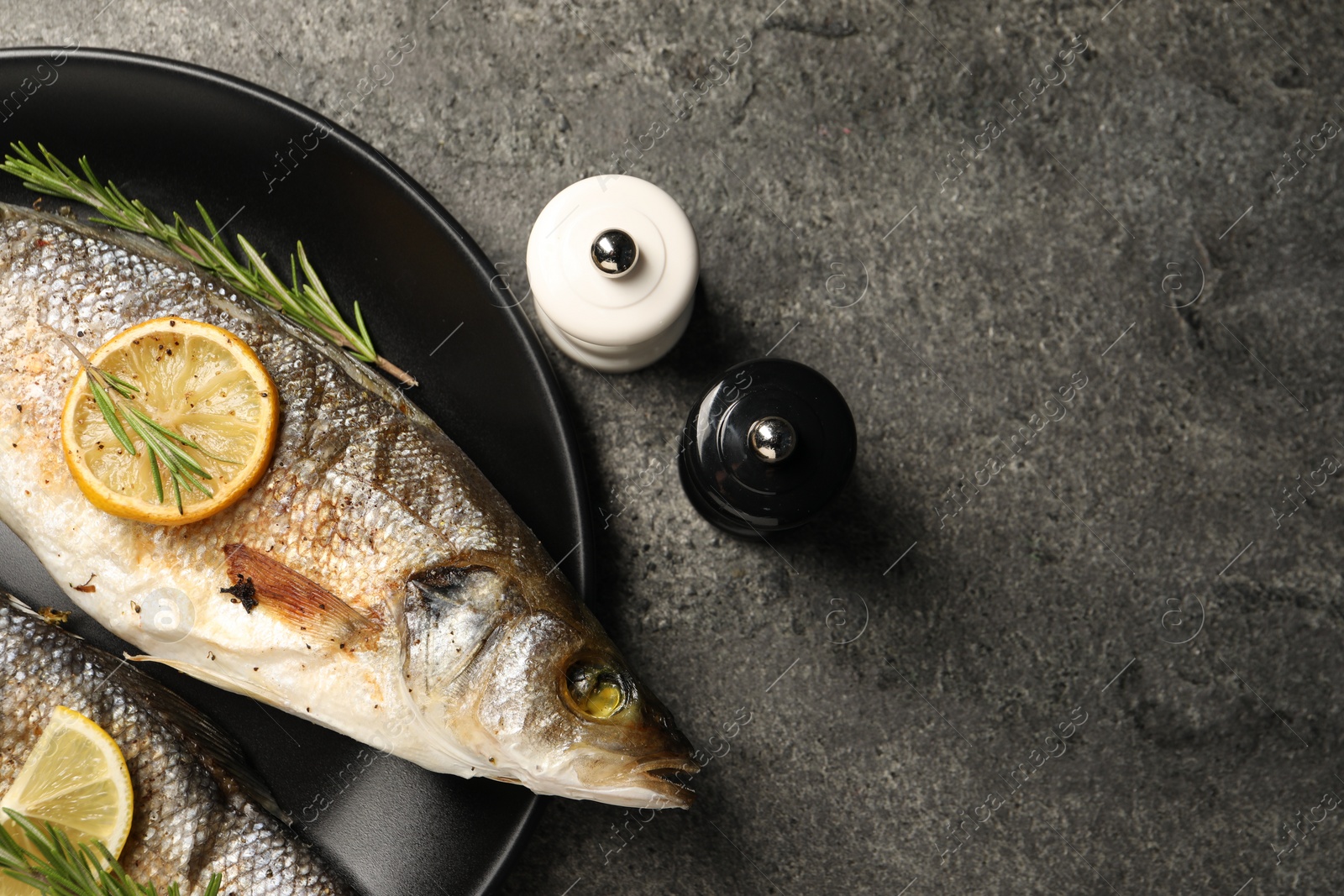 Photo of Delicious baked fish served on grey table, top view. Space for text