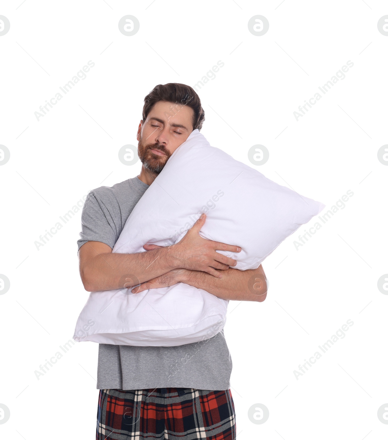 Photo of Sleepy handsome man hugging soft pillow on white background