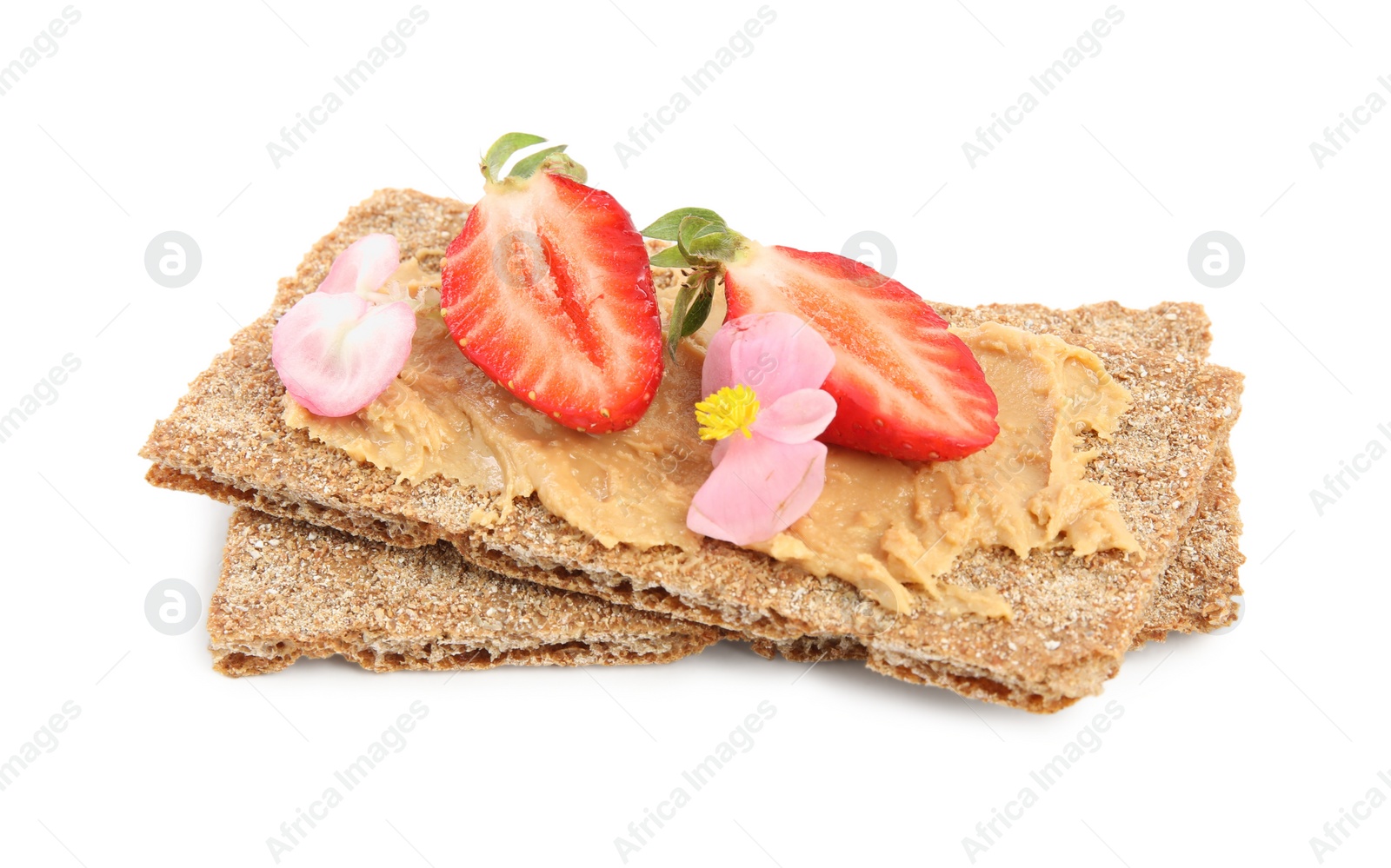 Photo of Fresh rye crispbreads with peanut butter, strawberry and flowers on white background