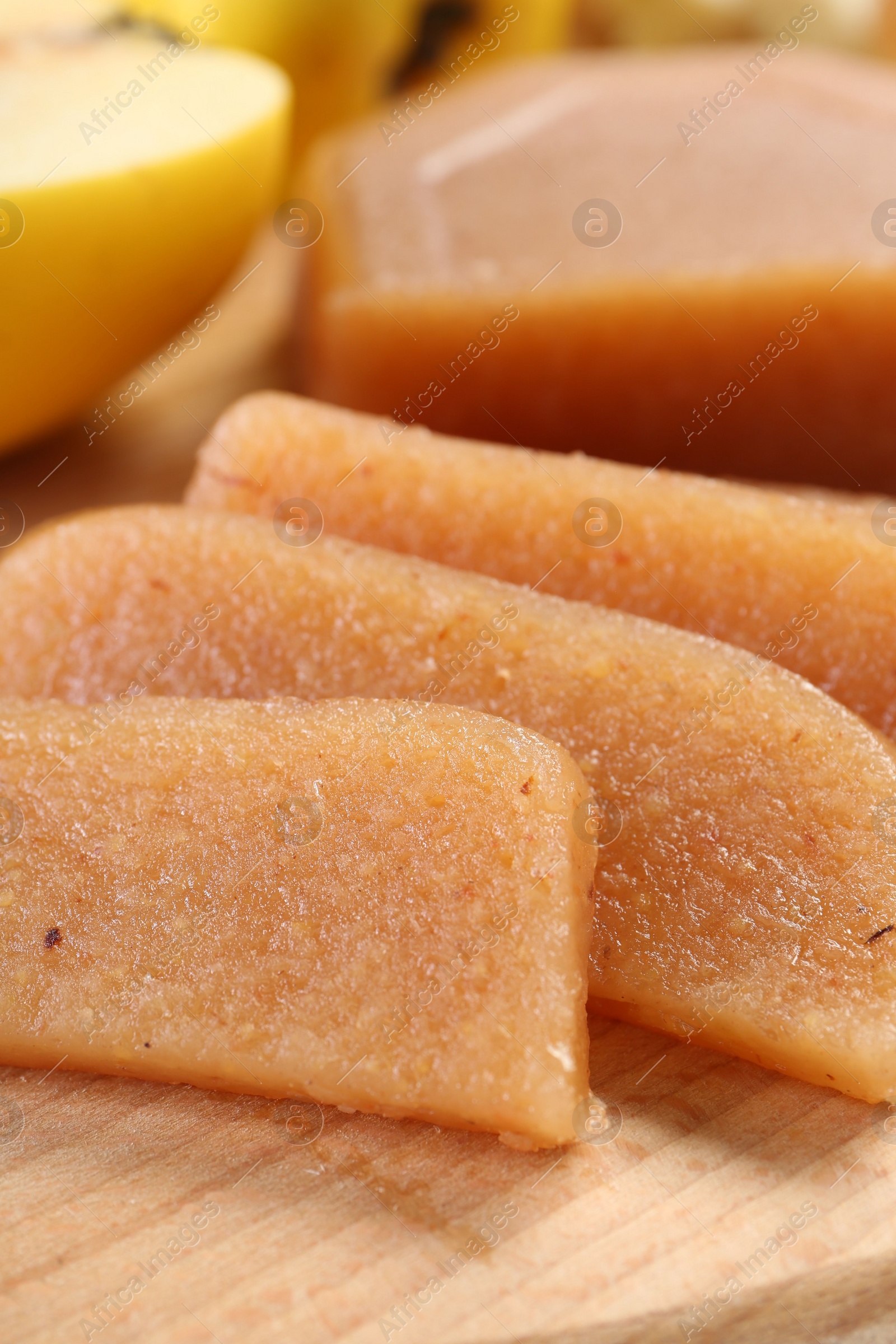 Photo of Tasty sweet quince paste and fresh fruits on wooden board, closeup