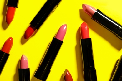 Photo of Flat lay composition with lipsticks on color background