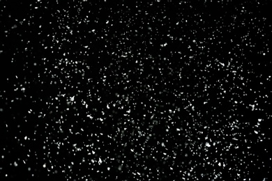 Photo of Snow flakes falling on black background. Winter weather