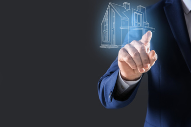Image of Real estate agent touching house illustration on virtual screen against dark background, closeup. Space for text